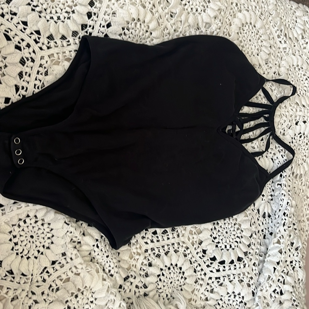Body suit with an open and strapped back style and criss crossed chest slit